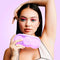 VUSH Aura Wireless Rechargable TENS Device with Travel Case held by a model with colorful eye makeup.