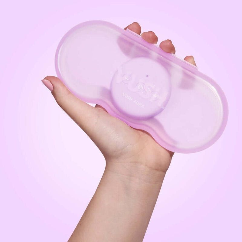 VUSH Aura Wireless Rechargable TENS Device with Travel Case held in hand, offering portable pain relief.