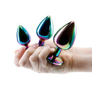 Adam & Eve Rainbow Heart Anal Plug Training Set showcasing three graduated metal plugs in a hand.