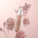 Playground Mood Maker Body & Massage Oil in a pink floral setting, highlighting its intimate and hydrating qualities.