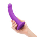 Together Tilt 6.5 inch Silicone Dildo and Harness Set Purple being held in a hand, showcasing its unique curved design.