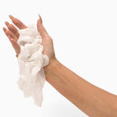A hand holding crumpled tissues, representing fresh and clean convenience with the Beloved Freshen Up Travel Kit.