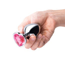 b-Vibe Jewel Metal Training Plug Set held in a hand, showcasing its elegant design and jeweled heart base.
