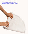 Dame Thro Waterproof Sex Blanket Oat being rolled, showcasing its stylish and functional design.