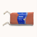 Dame Thro Waterproof Sex Blanket Copper in a rolled design with a blue label, perfect for comfortable intimacy.