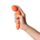 Dame Min Mini Wand Vibrator Papaya held in hand showcasing its compact design and vibrant color.