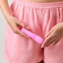 FemmeFunn Hana Thumping Bullet Vibrator Pink held by a person in pink shorts, showcasing its sleek design.