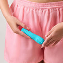 FemmeFunn Hana Thumping Bullet Vibrator Turquoise being held by a person in pink shorts.
