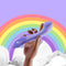 Biird Gii Glow Vibrator Lilac held in hand against a colorful rainbow background and soft clouds.