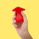 Cute Little Fuckers Morrie Mushroom Vibrator Red held in hand against a bright yellow background.