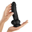 Shaft Model N 9.5 inch Liquid Silicone Dong with Balls Black held in a hand showcasing its realistic design.