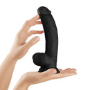 Shaft Model C 9.5 inch Liquid Silicone Dong with Balls Black held in hand showcasing its realistic design.
