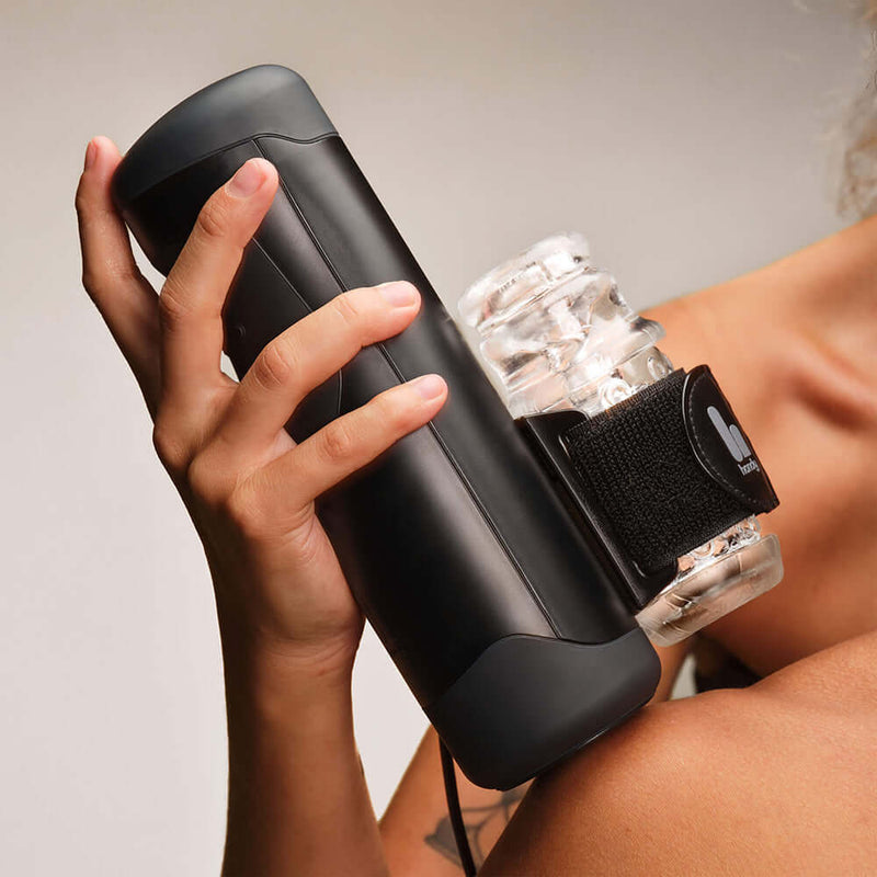 A person holding The Handy Interactive Stroker with a clear attachment, showcasing its sleek design and functionality.
