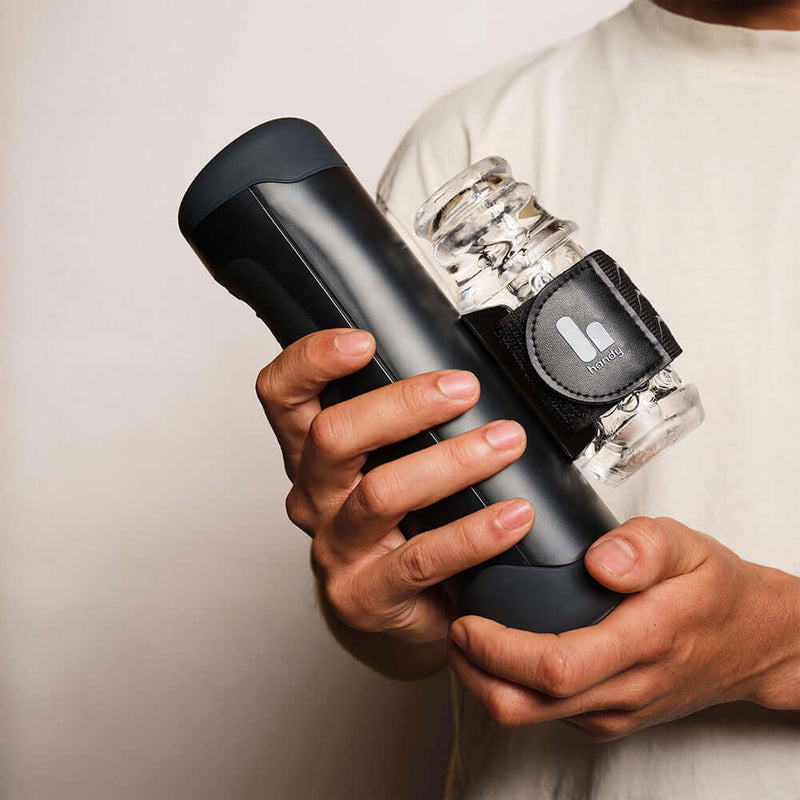 A person holding The Handy Interactive Stroker, a sleek device designed for interactive pleasure.
