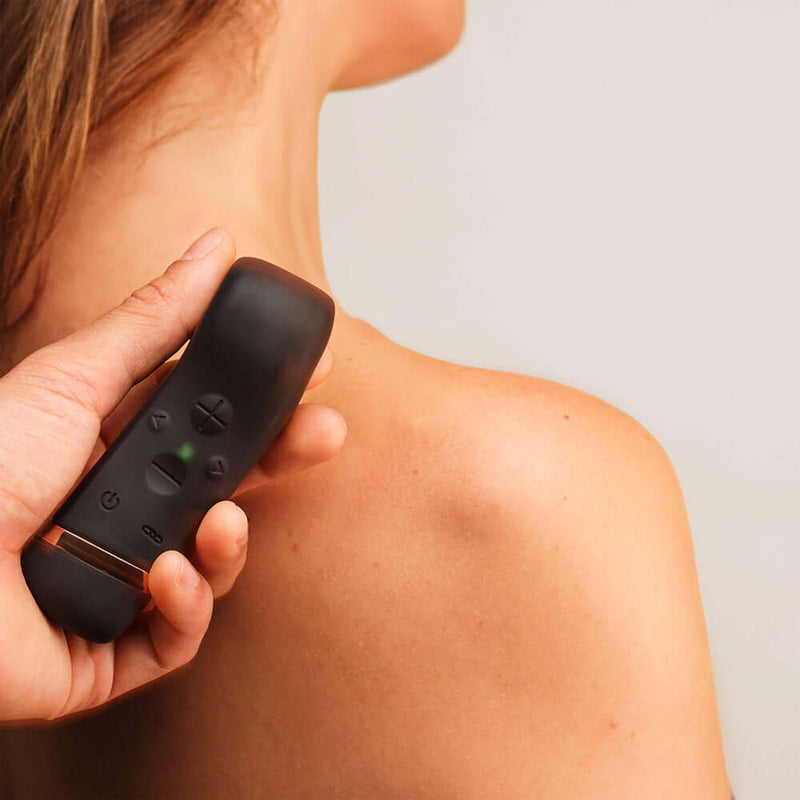 Person using Handy The Oh Vibrator Black on shoulder, showcasing innovative design and ResoTouch technology.