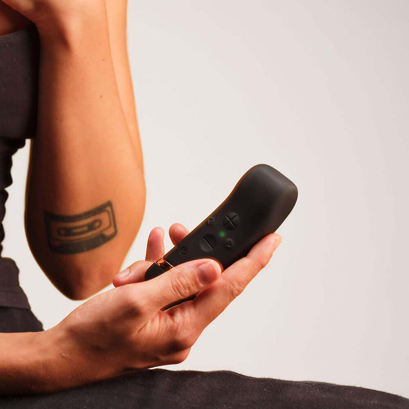Close-up of a person holding the Handy The Oh Vibrator Black with ResoTouch technology.
