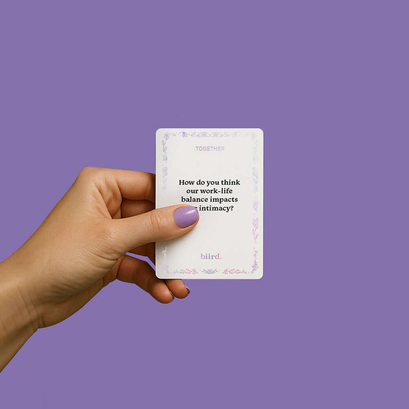 Hand holding a card from the Biird x Jouissance Club Together Couples Card Game with a thought-provoking question.