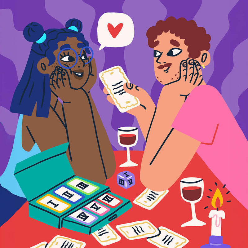 Couple enjoying the Biird x Jouissance Club Together Couples Card Game in a cozy setting with wine and candles.