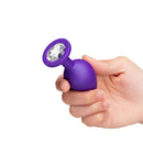 b-Vibe Jewel Butties Bundle showcasing a purple silicone anal plug held in hand with a decorative jeweled base.
