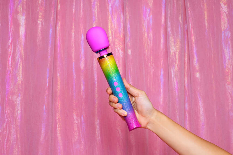Le Wand Petite All That Glimmers Ombre Massager held against a pink backdrop.