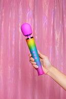Le Wand Petite All That Glimmers Ombre Massager held against a shimmering pink backdrop.