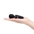 Le Wand Mini Micro Wand Black held in a hand, showcasing its portable design and compact size.