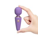 Le Wand Mini Micro Wand Vibrator Violet being held in hand, showcasing its compact design for discreet pleasure.