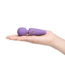 Le Wand Mini Micro Wand Vibrator Violet in a hand, showcasing its compact design for discreet pleasure.