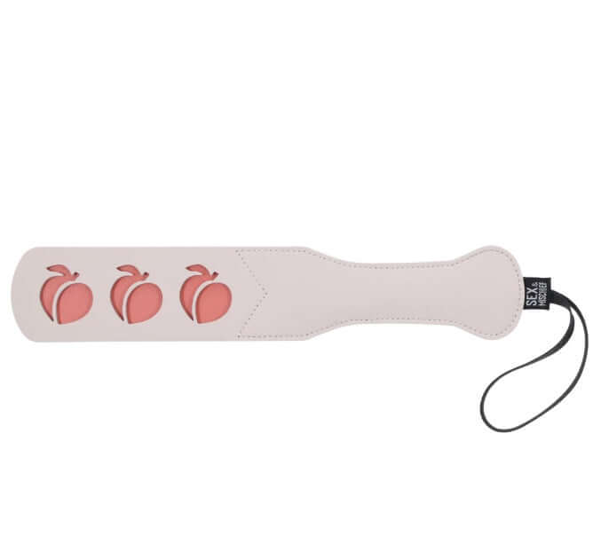 Peaches 'n CreaMe Peach Paddle by Sex&Mischief with peach-shaped cutouts, faux leather design, and wrist strap for playful spanking fun