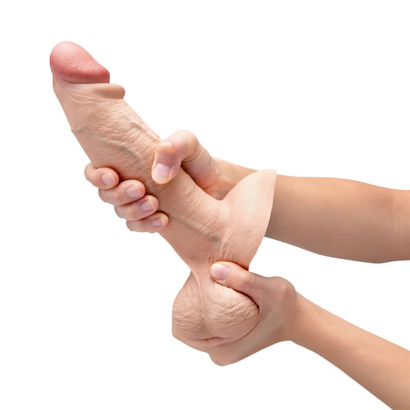 b-Vibe Slipskin Realistic Silicone Dildo 8 inch Girthy Cream being held and squeezed for realistic pleasure.