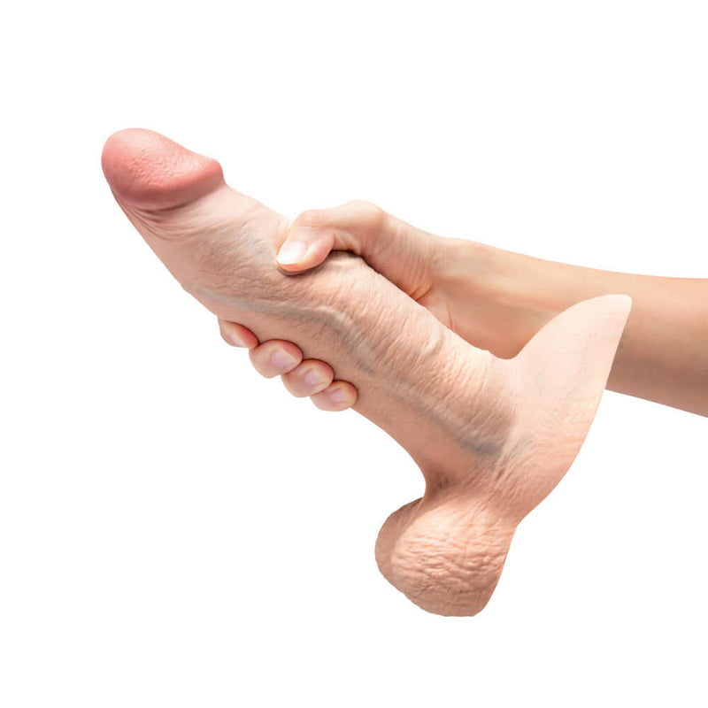 b Vibe Slipskin Realistic Silicone Dildo 9 inches Girthy Cream being held in hand, showcasing realistic design.