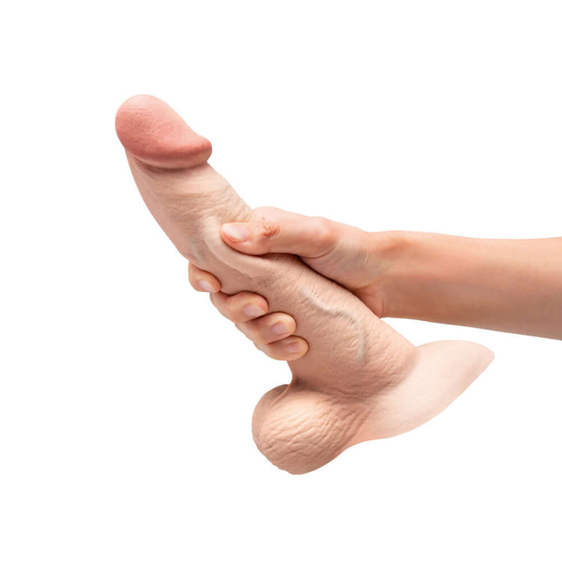 b-Vibe Slipskin Realistic Silicone Dildo 9 inch Curved Cream held in hand for realistic feel.
