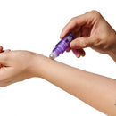Applying Eye Of Love Pheromone Roll-On Set Sunny Daze Lilac Dream on wrist for a captivating fragrance experience.