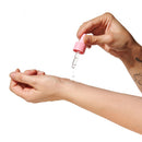 Applying Eye of Love Pheromone Parfum Oil 0.67 Oz Dropper Sunny Daze on wrist with dropper.