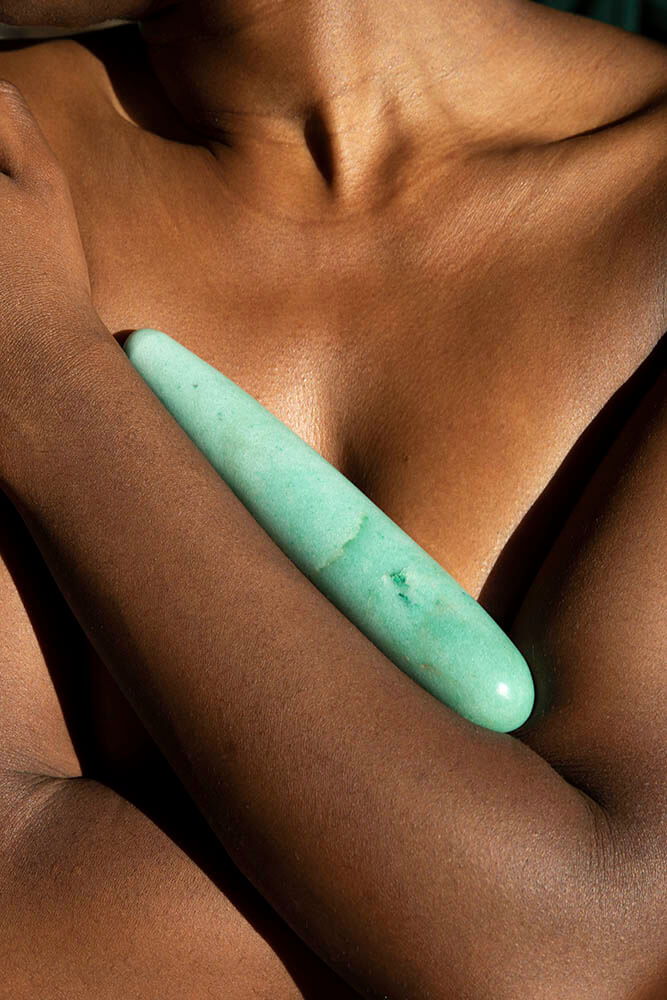 Chakrubs Indian Jade Original Green Aventurine Wand held against skin, highlighting its smooth texture and calming aura.