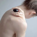 Chakrubs Xaga Yoni Egg Obsidian drilled held delicately against the shoulder for wellness and energetic protection.