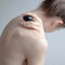 Chakrubs Xaga Yoni Egg Obsidian drilled held delicately against the shoulder for wellness and energetic protection.