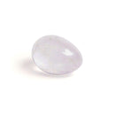 Chakrubs Prism Yoni Egg Clear Quartz drilled resting on a surface, showcasing its smooth, hand-carved design.