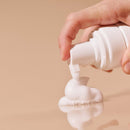 Person's hand dispensing Sex Au Naturel Prebiotic Intimate Wash Gentle Foam with a soft, soap-free texture.