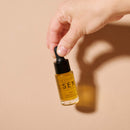 Slow Sex Anal Soothing Oil Before And After Care bottle held in hand against a neutral background.