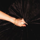 Hand gripping the luxurious texture of Splash Blanket The OG Extra Small Black, showcasing its waterproof quality.
