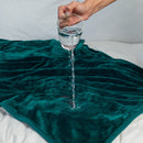 Splash Blanket The OG Small Emerald Green demonstrating waterproof feature with water being spilled on it.
