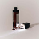 Eye of Love Matchmaker Crimson Kiss Pheromone Lip Gloss in a stylish tube with a shimmering applicator.