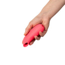 Dame Aer Air Pulse Suction Vibrator Coral held in a hand, showcasing its sleek design and vibrant color.