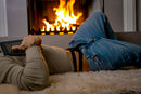 Male Power Eco Cozy Cutout Thong Green L/XL worn by a man relaxing near a cozy fireplace while reading.