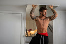 Male Power Mesh 2.0 Mini Short Red Large worn by a muscular man with tattoos, showcasing comfort and style.