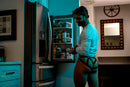 Male Power Mesh 2.0 Strappy Ring Jock Red L/XL showcased in a modern kitchen, featuring strappy design and a confident pose.