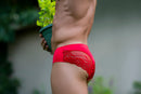 Male Power Sassy Lace Bikini Solid Pouch Navy XL showcased on a model holding a potted plant.