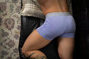 Male Power So Cumfy Gingham Boxer Brief Purple XL shown on a man resting on a couch with a stylish pattern.