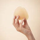 Uva Triangular Nipple Covers Caramel held in hand, showcasing their discreet triangular shape and caramel tone.